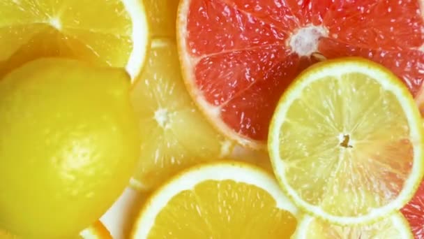 Замедленная съемка свежего лимона, падающего на оранжевый и грейпфрутовый ломтики на столе
 - Кадры, видео