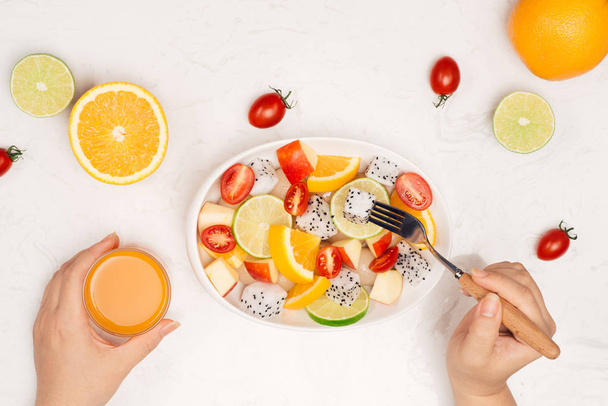 female Eating delicious summer tropical fruits salad for breakfast. - Photo, Image