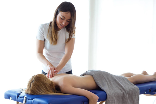 Young physiotherapist doing a back treatment to the patient in a physiotherapy room. Rehabilitation, medical massage and manual therapy concept. - Photo, Image