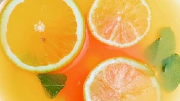 Primer plano video en cámara lenta de limonada fría con naranjas, pomelos y hojas de menta fresca
 - Metraje, vídeo