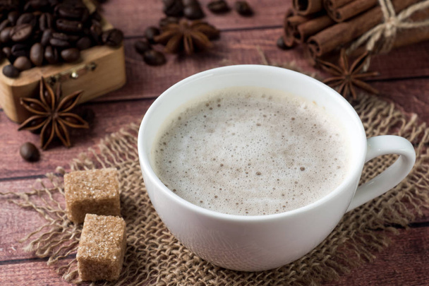 White coffee Cup and saucer with milk foam and cane sugar cinnamon Anise Coffee beans - Foto, Bild