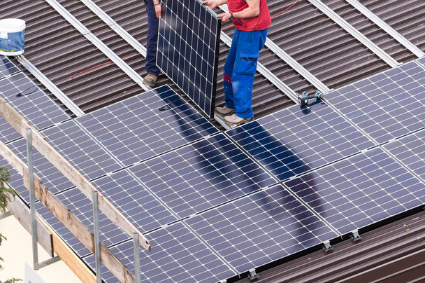 Panel słoneczny i pracowników. - Zdjęcie, obraz