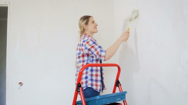 4k footage of beautiful smiling woman painting wall with roller - Footage, Video