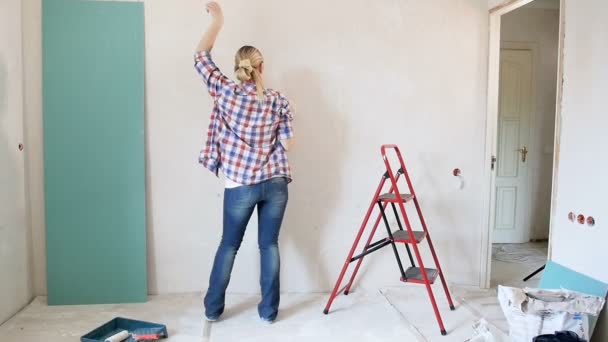 Imágenes en cámara lenta de la hermosa mujer joven bailando en casa bajo renovación
 - Metraje, vídeo