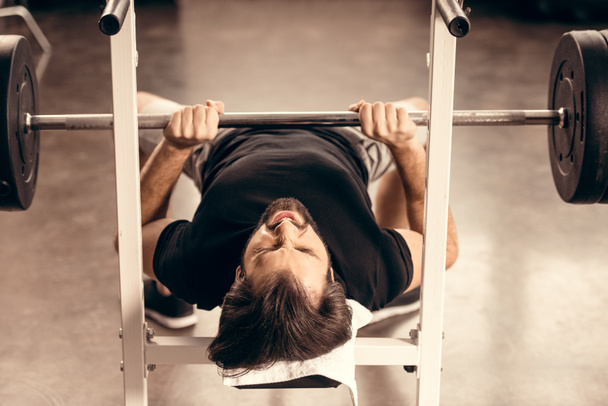 apuesto deportista haciendo ejercicio en press de banca en el gimnasio
 - Foto, Imagen
