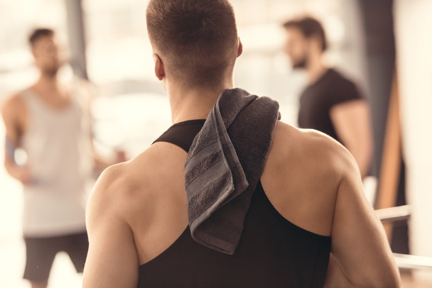 vista posterior del deportista muscular con toalla en el hombro
 - Foto, imagen