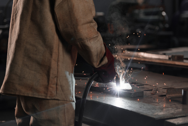 tiro recortado de la fabricación de metal de soldadura trabajador con chispas en la fábrica
  - Foto, Imagen