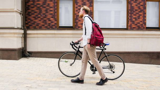 Elegante uomo hipster a piedi con bicicletta retrò sulla strada
 - Foto, immagini