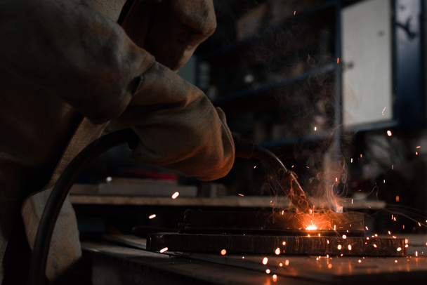 recortado tiro de fabricación trabajador soldadura de metal con chispas en la fábrica
  - Foto, Imagen