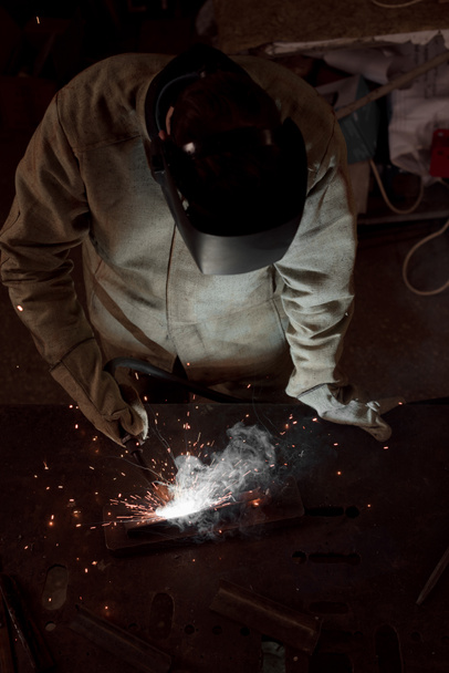 vista de ángulo alto de fabricación de metal de soldadura de trabajador con chispas en la fábrica
  - Foto, Imagen