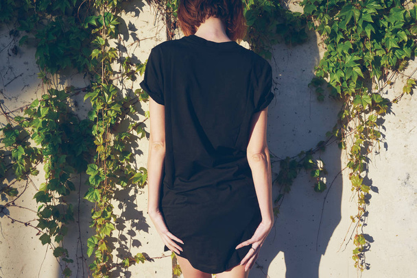Attractive young woman wearing black blank t-shirt  posing outdoors - Photo, Image