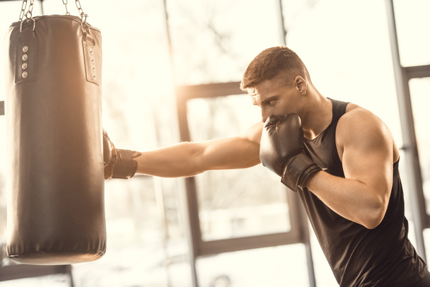 entraînement musclé jeune boxeur avec sac de boxe dans la salle de gym
  - Photo, image