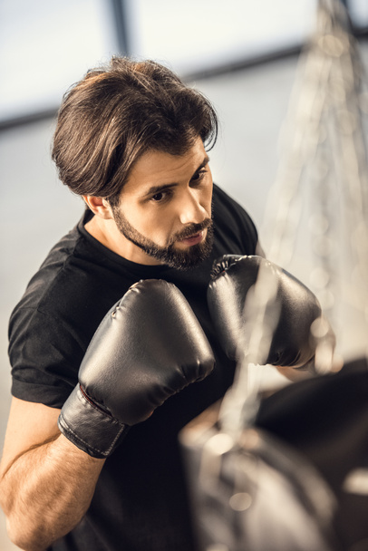 wysoki kąt widzenia przystojny młody mężczyzna w Rękawice bokserskie trening w siłowni - Zdjęcie, obraz