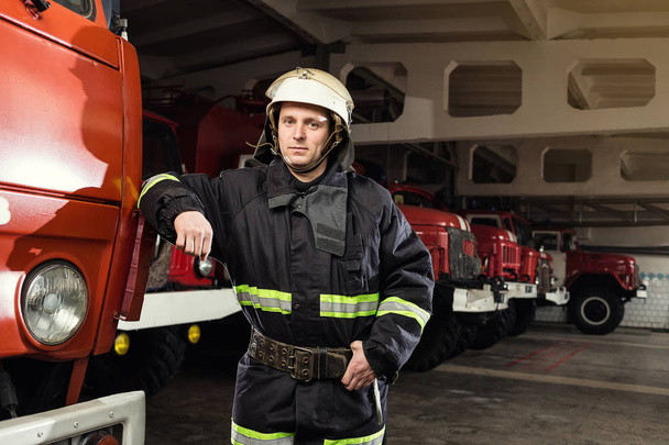 Fireman (firefighter) in action standing  near a firetruck. Emer - Photo, Image