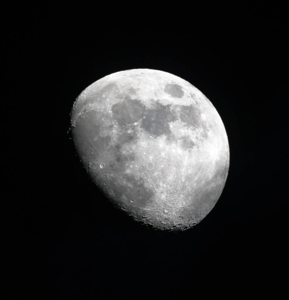 три чверті Місяця у великій деталізації в чорному нічному небі
 - Фото, зображення