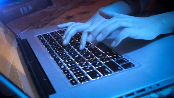 Closeup image of girl typing message on laptop at night - Foto, Bild
