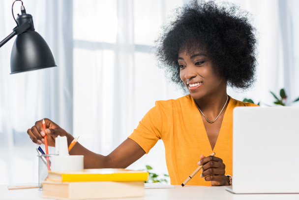 sorridente afro-americano freelance sul posto di lavoro a casa
 - Foto, immagini