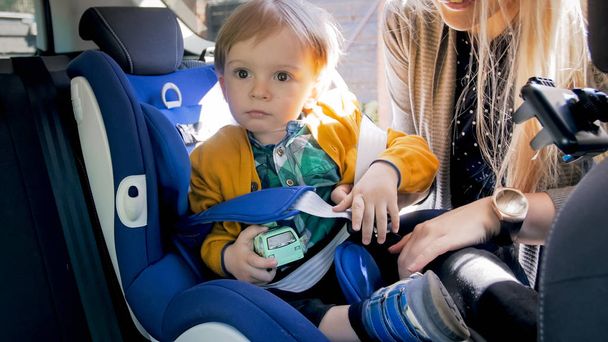 Retrato de menino adorável criança no assento de segurança do carro
 - Foto, Imagem