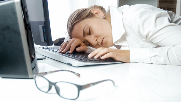 Porträt der schönen Geschäftsfrau, die im Büro auf der Tastatur schläft - Foto, Bild