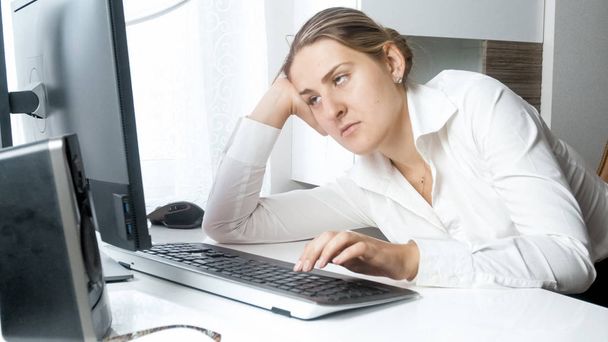Retrato de una joven empresaria sobrecargada de trabajo mirando la pantalla del ordenador
 - Foto, Imagen