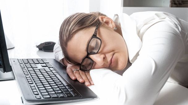 Retrato de la gerente trabajada durmiendo en el escritorio en la oficina
 - Foto, imagen