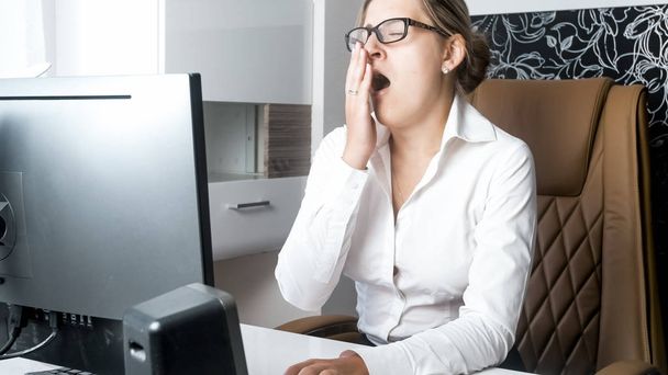 Portrét vyčerpaná mladé ženy pocit ospalosti a zející v kanceláři - Fotografie, Obrázek