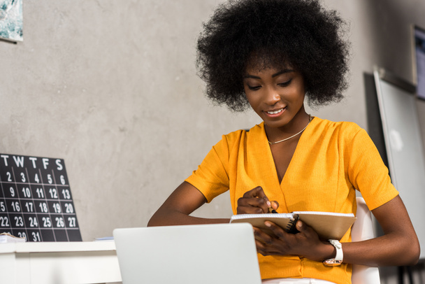 portrait of smiling african american female freelancer working at home - Photo, Image