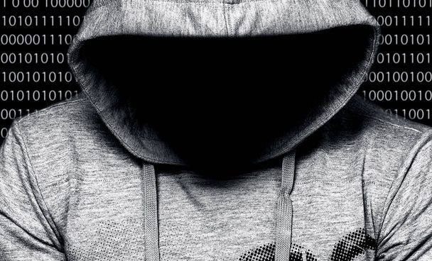 Hacker. Man in hood with face in a darkness with digital numbers behind - Photo, Image