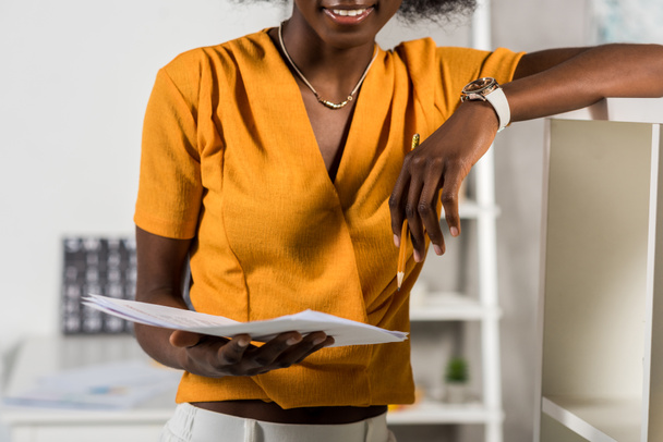 Vista parcial de la hermosa afroamericana freelancer con papeles en casa oficina
 - Foto, imagen