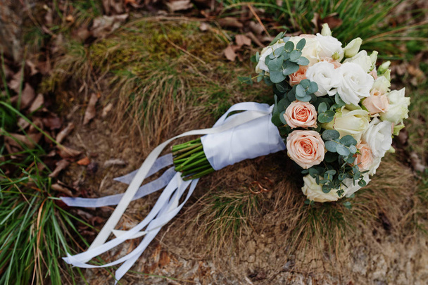 Wedding bouquet with white ribbons on grass. - Foto, Bild