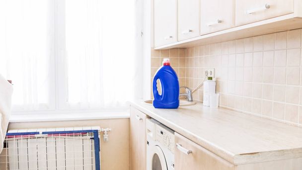 Big bottle of liquid detergent standing on tabletop at laundry in house - Photo, Image