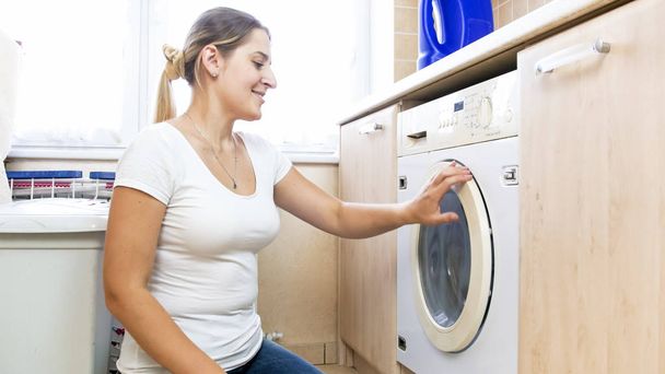 Retrato de bela jovem dona de casa fazendo lavanderia
 - Foto, Imagem