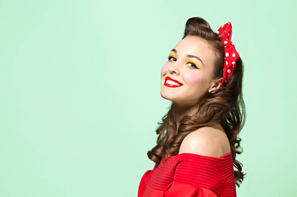 Beautiful young woman with pinup make-up and hairstyle. Studio shot on white background - Photo, image