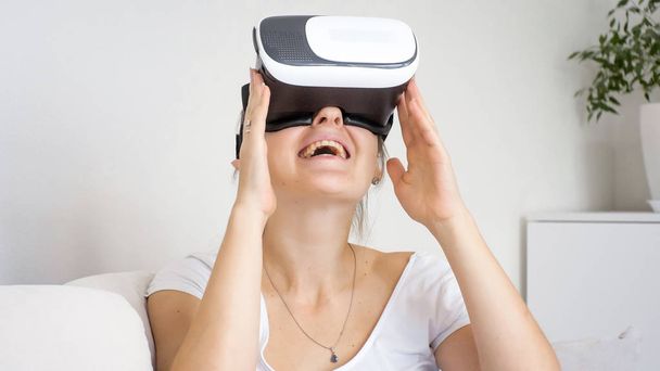 Портрет смеющейся девушки в наушниках VR
 - Фото, изображение