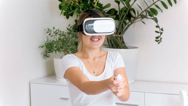 Портрет взволнованной молодой женщины, играющей в шутер в шлеме VR
 - Фото, изображение
