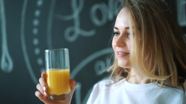Young beautiful woman drinking juice, girl drink orange fresh on morning breakfast - Imágenes, Vídeo