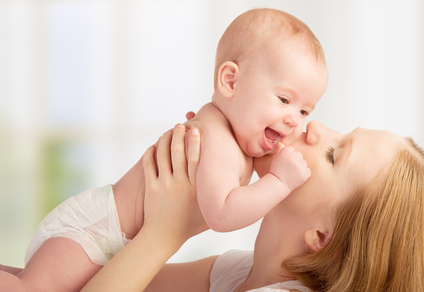 Feliz madre joven besando a un bebé
 - Foto, imagen
