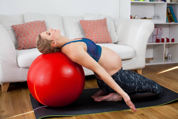 Uma jovem mulher grávida bonita está envolvida em ioga para mulheres grávidas. Desporto para mulheres grávidas. Saúde. Ioga grávida. Maternidade
. - Foto, Imagem