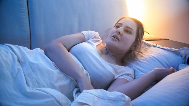 Portrét vyděšená mladá žena probuzení v noci kvůli noční můra - Fotografie, Obrázek