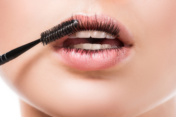 cropped image of woman applying mascara on eyelashes on lips isolated on white - Фото, изображение