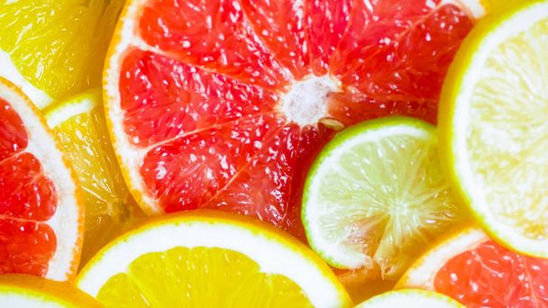 Closeup image of freshly cut citrus fruits lying on table - Photo, Image