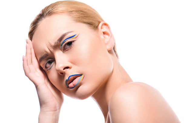 irritated woman with colored makeup with lines looking at camera isolated on white - Photo, image