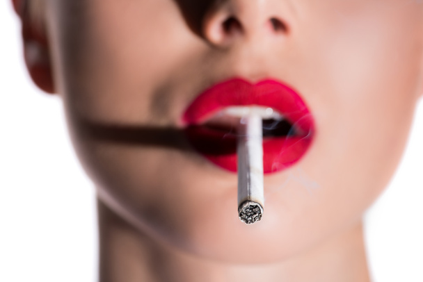 cropped image of woman holding cigarette with red lips, cigarette on foreground - Photo, Image