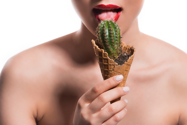 cropped image of woman licking cactus potted in ice cream cone isolated on white - Valokuva, kuva