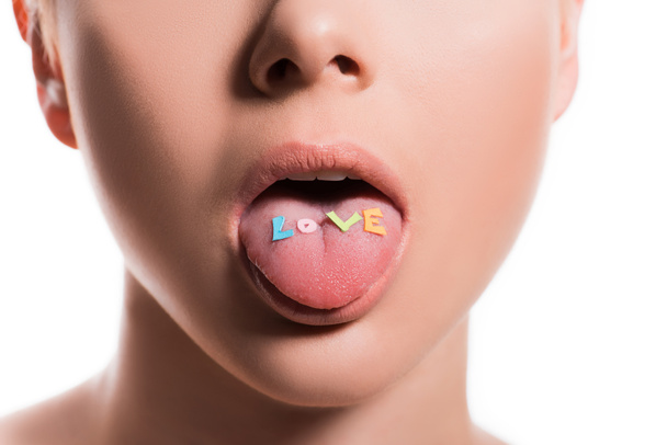imagem cortada de mulher colando a língua para fora com palavra amor isolado no branco
 - Foto, Imagem