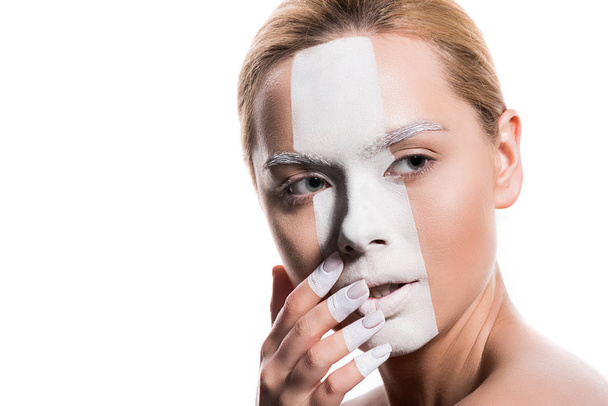 beautiful woman with white paint on face and fingers touching lips isolated on white - Zdjęcie, obraz