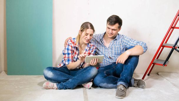 junge Familie surft auf digitalem Tablet-Computer im Haus im Bau - Foto, Bild