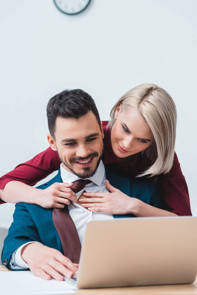 schön lächelnde junge Geschäftskollegen flirten während der gemeinsamen Arbeit im Büro  - Foto, Bild