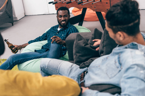 cropped image of group of multiethnic friends sitting and talking to each other - Фото, зображення