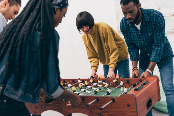 young multiethnic friends playing table soccer  - Foto, Imagem